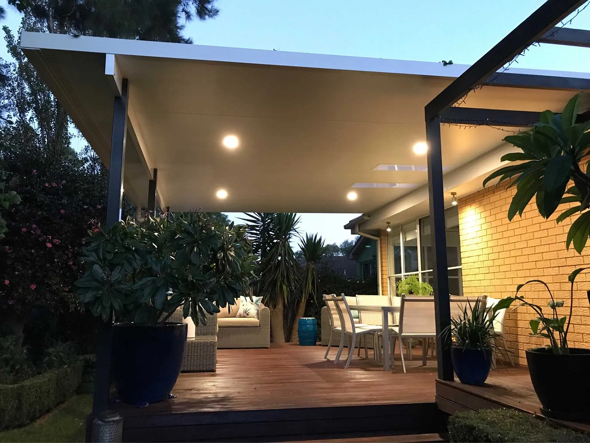 A modern home with a large, grey retractable awning extended over a patio, providing shade and comfort.