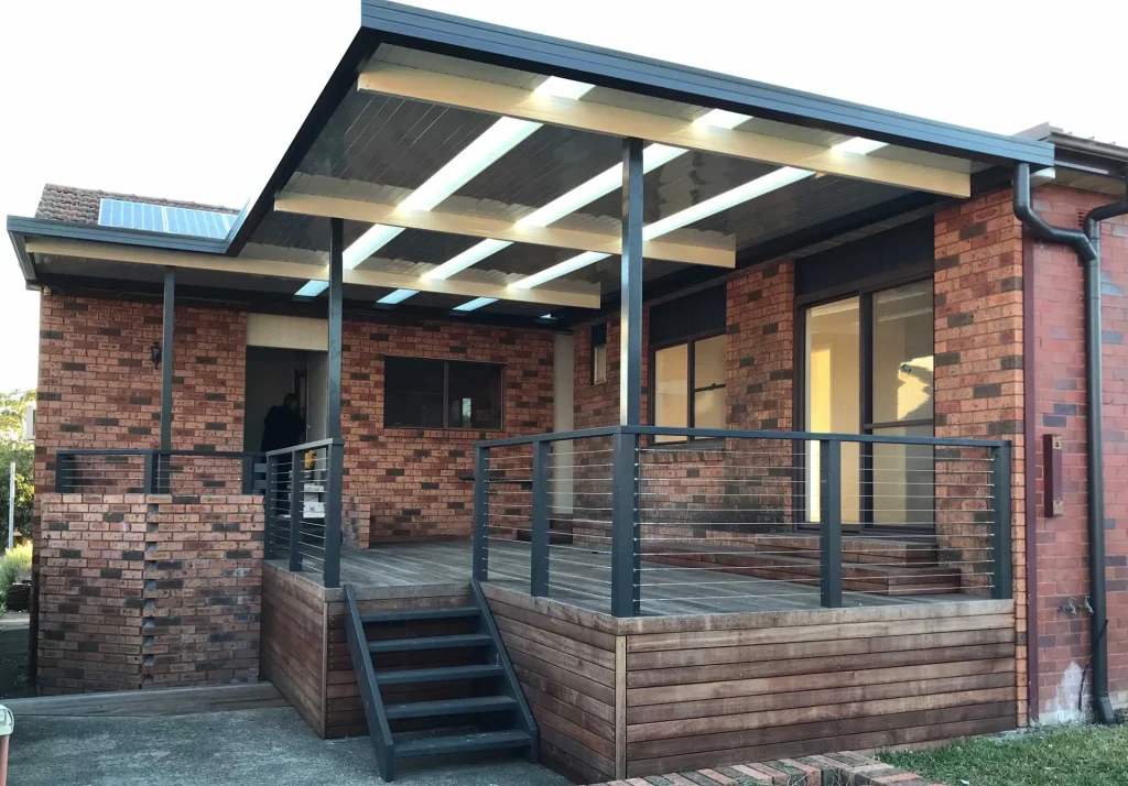 A modern home with a large, stylish awning extending over a patio area, providing shade and enhancing outdoor living.